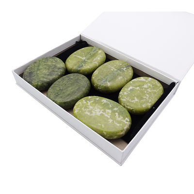 Piedra caliente curativa de Jade Xiuyan para masajes profesionales y relajación en spa.