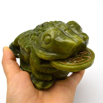 La talla de un sapo de jade verde que atrae a la riqueza para el éxito financiero en el Fengshui