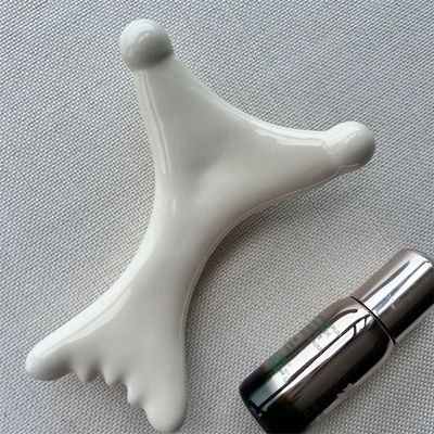 OEM/ODM Gua Sha de cerámica en forma de X Mascarilla de masaje Salón de belleza esencial para la relajación facial